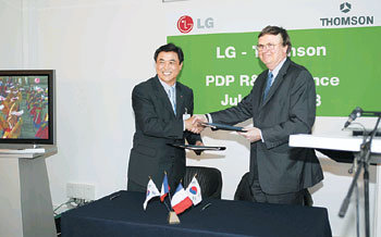 LG전자 우남균 사장(왼쪽)과 프랑스 톰슨의 샤를 드에리 사장이 PDP 공동 연구개발에 대한 전략적 제휴 계약을 한 뒤 악수하고 있다. 사진제공 LG전자