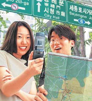 한 커플이 휴대전화로 길을 찾고 있다. GPS기능을 갖춘 휴대전화를 이용하면 지도상에서 현재 위치를 확인해 가며 목적지를 찾을 수 있다.  사진제공= SK텔레콤