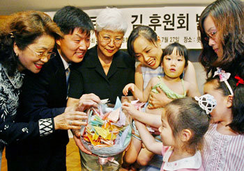 27일 서울 중구 소공동 롯데호텔에서 열린 로버트 김 후원회 발족식에서 이웅진 후원회장(왼쪽에서 두번째)과 로버트 김씨의 부인 장명희씨(왼쪽에서 세번째)가 김씨에게 전해줄 사랑의 종이학을 행사 참석자들로부터 받고 있다. -권주훈기자