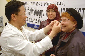 인천 한길안과병원 의료진이 우즈베키스탄에서 시력이 나쁜 현지 주민에게 한국에서 가져간 안경을 씌워주고 있다. -사진제공 인천 한길안과병원