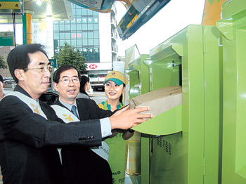 12일 서울 서초구 서초동 서일주유소에 설치된 물품기증함에 아름다운가게 박원순 상임이사(가운데)와 LG정유 박영호 상무(왼쪽)가 옷가지를 넣고 있다. -사진제공 아름다운가게