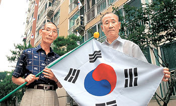 15일 광복절을 앞두고 아파트 단지 전체에 태극기 달기 운동을 벌인 장대홍(오른쪽), 김재옥 할아버지. -사진제공 서울 송파구