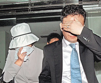 양길승 전 대통령제1부속실장에 대한 몰래카메라의 촬영 제작을 의뢰한 것으로 알려진 홍모씨 부부가 긴급체포된 후 20일 새벽 청주지검을 나서고 있다. -청주=연합