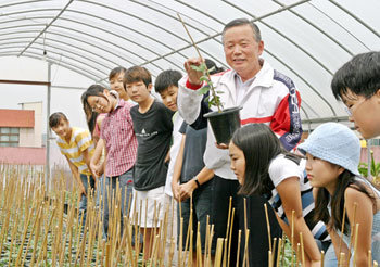 이강연 교장이 국화를 키우는 학교 온실에서 21일 학생들과 함께 활짝 웃고 있다. -권주훈기자