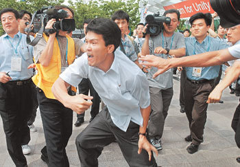 24일 2003 대구유니버시아드 프레스센터 앞에서 북한의 인권상황을 비난하는 집회를 갖던 국내 3개 시민단체와 북한기자들이 충돌했다. 한 북한기자(앞)가 시민단체에 항의하고 있다. -대구=연합