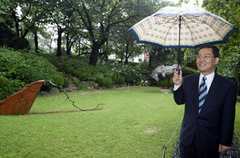 24일 오후 서울 성곡미술관의 야외조각공원에서 고승덕 변호사가 빗속에 우산을 쓰고 작품에 대해 얘기하고 있다. -박영대기자