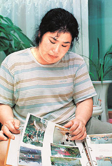 교통사고로 숨진 아들의 모교에 장학기금으로 1억원을 기탁한 김순희씨가 아들의 사진첩을 뒤적이고 있다. -광주=연합