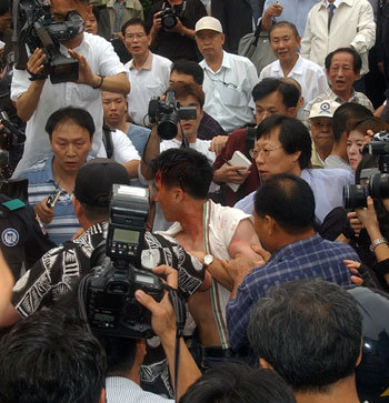 우익단체 사람들이 29일 광화문 열린마당에서 열린 반핵.반북 시위에서 인공기를 빼앗은 경찰을 구타하고 있다. [연합]