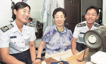9일 김일락 할머니가 공군사관학교 세탁소 내 수선소를 찾은 남녀 공사생도들과 정담을 나누고 있다. -사진제공 공군