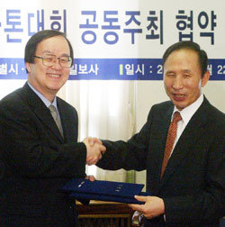 이명박 서울시장(오른쪽)과 김학준 동아일보 사장이 22일 서울시청에서 서울국제마라톤대회의 공동 주최를 위한 협약 조인식을 가진 뒤 협약서를 교환하고 있다. -원대연기자