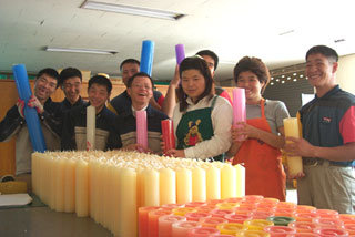 엠마우스산업에서 일하는 정신지체장애인들이 1일 KS 마크를 획득한 양초를 들어보이며 활짝 웃고 있다. -광주=정승호기자