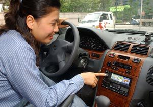 휴대전화 텔레매틱스 ‘네이트 드라이브’ 서비스 이용자가 차량내 단말기 화면을 통해 목적지에 이르는 경로를 살펴보고 있다. 사진제공 SK텔레콤