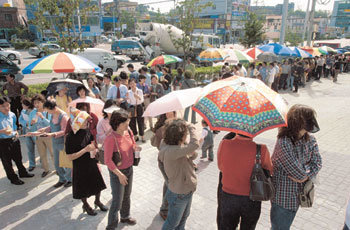 6일부터 분양신청 접수가 시작된 울산 중구 약사동 푸르지오 아파트 모델하우스 앞에서 분양신청자들이 길게 줄지어 서 있다. 이들 옆에는 분양권을 사들이려는 일명 ‘떴다방’들이 파라솔을 설치해 놓고 있다. -울산=정재락기자