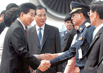 노무현 대통령이 19일 아시아태평양경제협력체(APEC) 정상회의에 참석하기 위해 태국 방콕에 도착한 뒤 영접 나온 태국 정부 인사들과 악수하고 있다. -방콕=박주일기자
