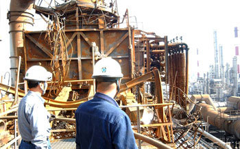 울산 SK㈜ 중질유분해공장 직원들이 21일 화재 발생지점인 가열기 위에서 흉하게 일그러진 설비들을 살펴보고 있다. -울산=연합