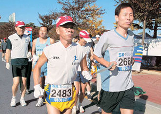 1급 시각장애인 이윤동씨(오른쪽)가 페이스메이커와 손목에 끈을 묶은 채 힘차게 달리고 있다. -경주=원대연기자