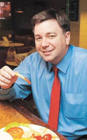 빌 케퍼 이사가 정통 미국식 햄버거맛을 자랑하는 내쉬빌 스테이크 하우스에서 더블치즈버거를 먹고 있다.-이종승기자