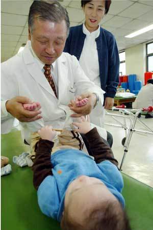 박창일 교수가 간호사의 도움을 받아 장애 아동을 진료하고 있다.원대연기자 yeon72@donga.com