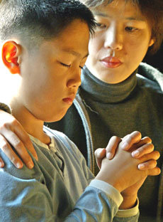 백혈병에 걸린 엄마를 살려달라고 기도하는 김홍태군과 이를 안쓰럽게 지켜보는 김군의 어머니 이미예씨. -김미옥기자