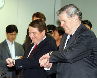 제임스 켈리 미국 국무부 동아시아태평양 담당 차관보(오른쪽)는 20일 한국정부와 2차 6자회담 개최에 관한 이틀간의 협의를 시작했다. 이날 외교통상부 청사 회의실에 도착한 켈리 차관보와 토머스 허버드 주한미국대사(가운데)가 빙긋이 웃으며 손목시계로 시간을 동시에 확인해 눈길을 끌었다. -연합