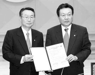 어윤대 고려대 총장(오른쪽)과 김종량 한양대 총장이 25일 한양대 백남학술정보관에서 학술교류 협정을 체결한 뒤 협정서를 들어 보이고 있다. -원대연기자