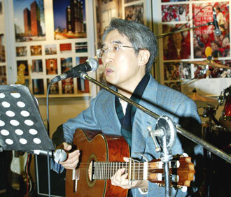 교보생명 신창재 회장이 12일 교보생명 세종로 본사 1층 로비에서 여사원모임이 주최한 ‘사랑나눔 호프데이’ 행사에 참가해 기타를 치면서 노래하고 있다. -연합