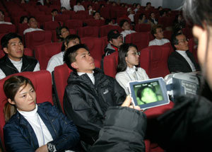 15일 밤 서울 충무로 스카라극장에서 개막한 ‘잠안자고 영화보기’ 행사에서 캠코더를 든 진행요원이 참가자들을 촬영하며 잠들지 않았는지를 확인하고 있다. 전영한기자