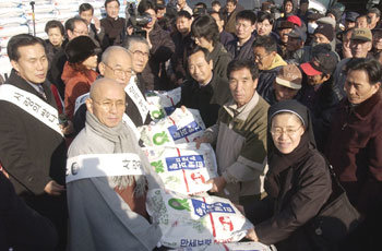 사랑의 실천 국민운동본부 회원들이 26일 오후 서울 종묘공원 앞에서 복지시설에 전달하기 위한 ‘사랑의 쌀’ 1000포대를 옮기고 있다. -박영대기자