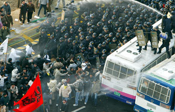 29일 오후 서울 여의도 국회 앞에서 열린 한국-칠레 자유무역협정 후 비준에 반대하는 농민들이 집회를 가진뒤 국회로 진입하려 하자 경찰이 물대포를 쏘며 저지하고 있다. -연합