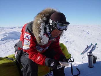 운행 중의 휴식시간 오희준 대원이 지친표정으로 썰매에 앉아 간식을 먹고있다.