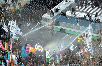 자유무역협정(FTA)에 반대하는 농민들이 8일 서울 여의도 국회의사당 쪽으로 다가가자 경찰이 버스 위에서 물을 쏘아대며 저지하고 있다. -원대연기자