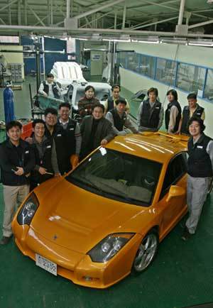 국내 여섯 번째 완성차 업체인 프로토자동차의 경기 용인시 공장내부 전경. 김한철 사장(왼쪽에서 다섯 번째)과 직원들이 독자 개발한 전통 미드십 스포츠카 ‘스피라’를 둘러서 있다.용인=이종승기자 urisesang@donga.com