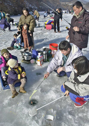 '아빠는 빙어 잡고, 우리는 썰매 타고.' 춘천호 신포리권에서 빙어낚시를 즐기는 가족들의 모습이 정겨워 보인다. 동아일보 자료사진