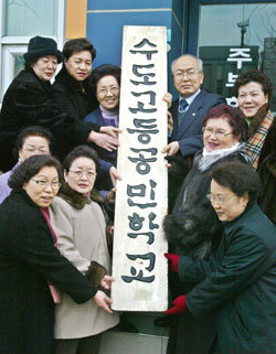 28일 오전 서울 용산구 갈월동 수도고등공민학교 유수열 교장과 졸업생들이 아쉬움 속에 반세기 동안의 수업을 마치며 학교의 현판을 내렸다. -권주훈기자