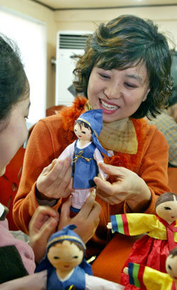 권선희씨가 서울 구로구 궁동 ‘서울 모자의 집’에서 아이들과 함께 신랑 신부 모양의 종이인형을 만들며 작은 기쁨을 전달하고 있다.  -이훈구기자