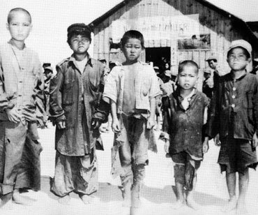 6·25전쟁고아들 가운데 왼쪽에서 두번째 소년이 군복을 걸쳐 입은 모습이 눈에 띈다.  -다큐멘터리 한국전쟁 자료사진