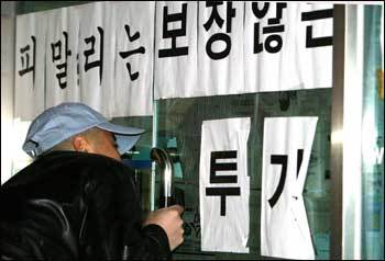 직장폐쇄된 외환카드22일 밤 직장폐쇄 조치가 내려지면서 출입이 통제된 서울 방배동 외환카드 본사에서 소식을 듣고 온 한 노조원이 건물안을 들여다보고 있다.[연합]
