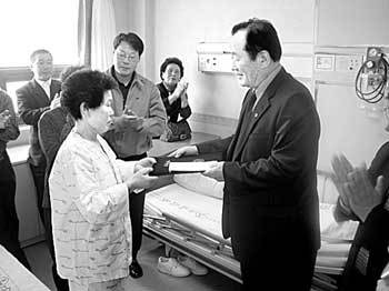 24일 전남 목포 중앙병원 입원실에서 지귀예 할머니가 대불대 이경수 총장에게 2억원의 장학금을 전달하고 있다. 사진제공 대불대