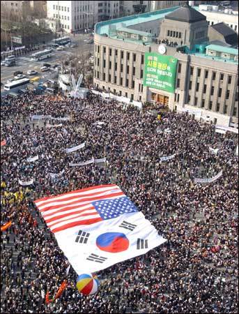 시청앞 태극기를 둘러싼 인파삼일절인 1일 오후 반핵반김정일국권수호국민대회협의회 주최로 서울시청 광장앞에서 열린 친북좌익척결, 부패추방 국민대회에 수만인파가 몰린 가운데  참가자들이 대형 태극기와 성조기를 흔들고 있다.[연합]