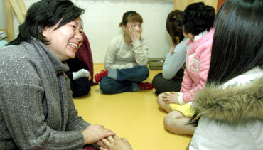 비행소녀들의 ‘엄마’인 김현주씨(44)가 2일 오후 서울 송파구 방이동 ‘딸부잣집’에서 손을 잡아주며 ‘딸’들의 고충을 들어주고 있다.   -원대연기자