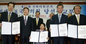 유지담 중앙선거관리위원장(왼쪽에서 두번째)이 16일 선관위에서 열린 제17대 비례대표 당선증 교부식에서 당대표로 참석한 열린우리당 장향숙 의원(가운데) 등과 기념촬영을 하고 있다. -김미옥기자