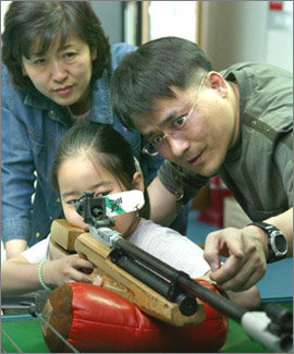 서울 목동사격장에서 아버지 심형희씨(오른쪽)의 설명을 들으며 공기총을 겨누고 있는 딸 지원양. 뒤는 어머니 임선희씨. 강병기기자
