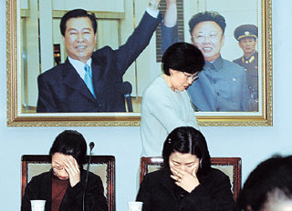 민주당이 27일 눈물의 사무처 직원 해단식을 가졌다. 이날 민주당은 서울 여의도 당사에서 마지막 사무처 당직자 간담회를 통해 “각자 흩어진 이후라도 50년 전통의 민주당을 반드시 일으켜 다시 만나자”고 서로를 위로했다. 손을 맞잡은 김대중 전 대통령과 김정일 국방위원장의 사진아래에서 두 여직원이 눈물을 흘리고 있다.-서영수기자