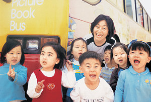 이상희씨가 운영하는 ‘그림책버스’ 앞에서 어린이들과 즐거운 시간을 갖고 있다. 사진제공 이상희씨