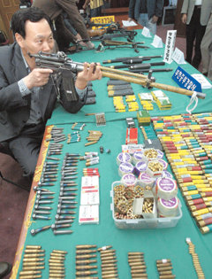 6일 오전 경기 부천중부경찰서에서 경찰 관계자가 금형기술자 서모씨가 채권자를 살해하는 데 쓴 사제총 사용방법을 설명하고 있다. 책상 위에는 압수된 일반 및 사체총 실탄.-부천=연합