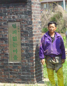 경기 화성시 하일마을 전갑철 이장이 마을 어귀에 세워진 ‘범죄 없는 마을’ 기념비 앞에 섰다.-사진제공 화성시청