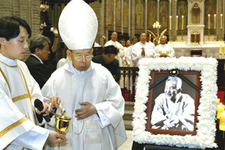 11일 구상 선생 장례미사에서 김수환 추기경(가운데)이 흰 국화에 싸인 선생의 영정과 관 주위를 돌며 성수를 뿌리고 있다.-김미옥기자