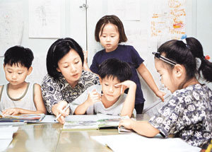 밀린 학습지나 교재에서 아이들이 흥미를 가질만한 부분을 골라 스크랩해주면 훌륭한 새 교재가 만들어진다. 초등학생들이 어린이집에서 교사와 함께 공부하는 모습.동아일보 자료사진