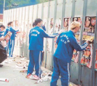 강서구의 한 나이트클럽 직원들이 도로변에 붙인 자신들의 업소 광고물을 스스로 제거하고 있다.-사진제공 강서구