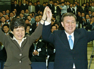 한나라당 박근혜 대표(왼쪽)가 19일 국회 소회의실에서 신임 원내대표로 선출된 김덕룡 의원의 손을 잡고 축하하고 있다. 당내 비주류 길을 걸어온 두 사람은 주요 사안 발생시 수시로 교감을 해왔다.-서영수기자